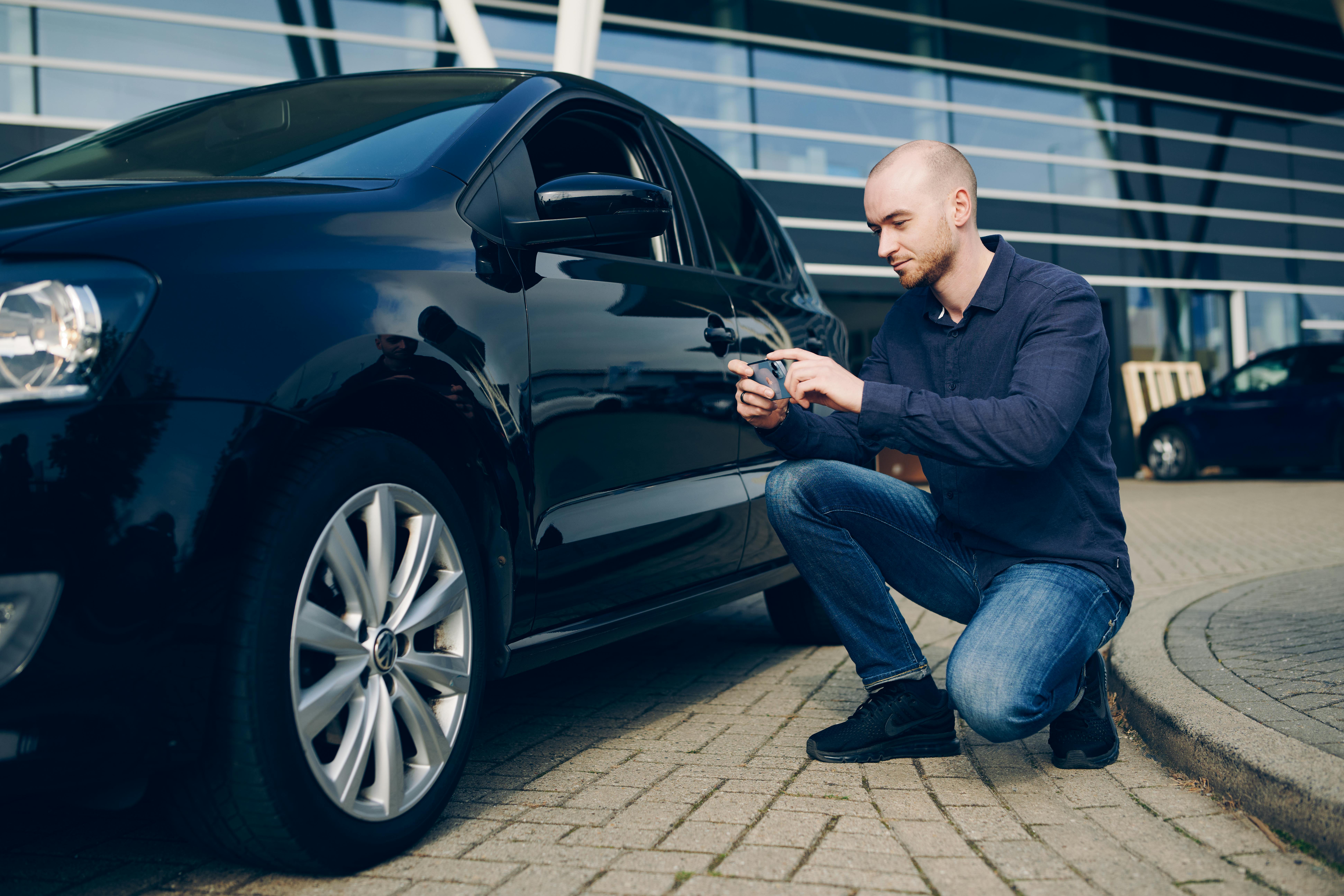 Driver taking photo of car damage